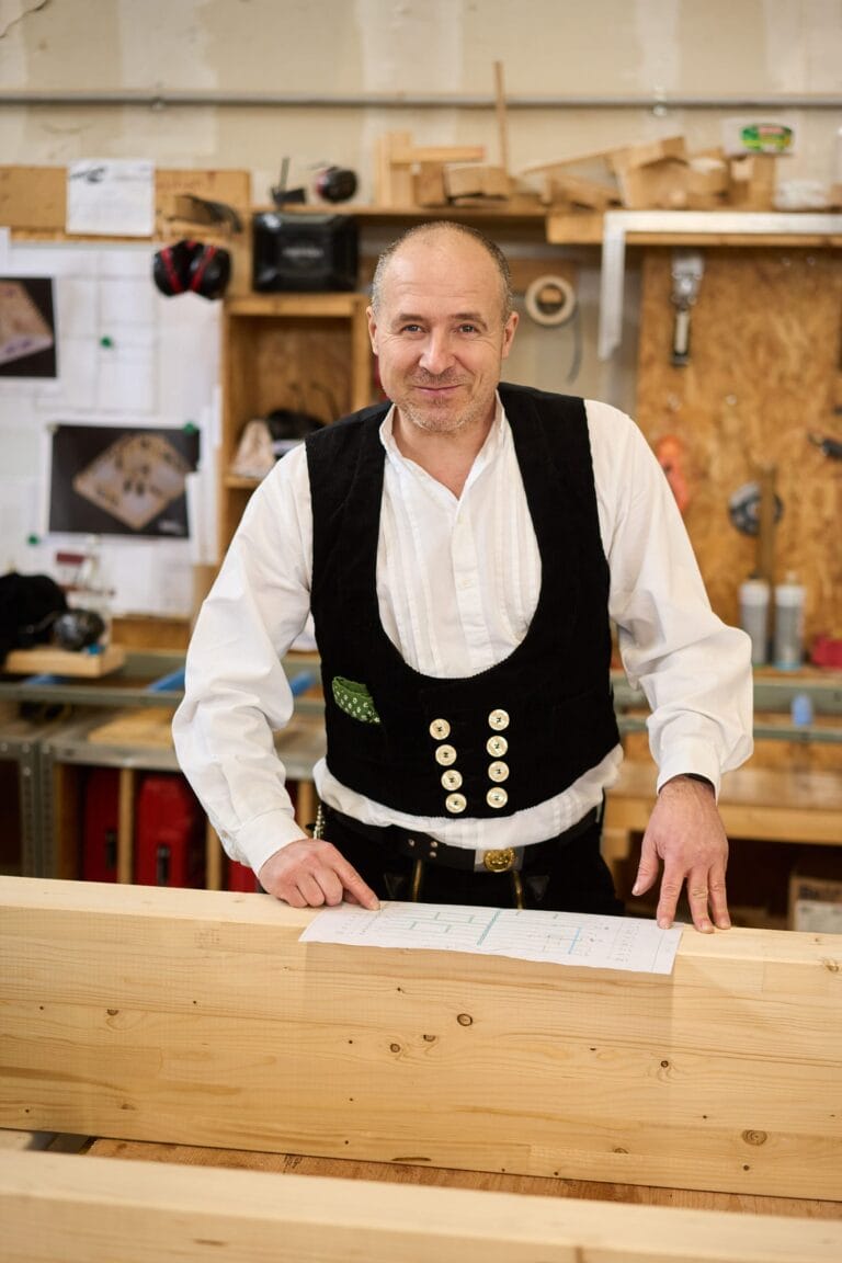 Zimmermann hobelt Holzbalken in der Werkstatt – mitarbeiterfotos Mannheim