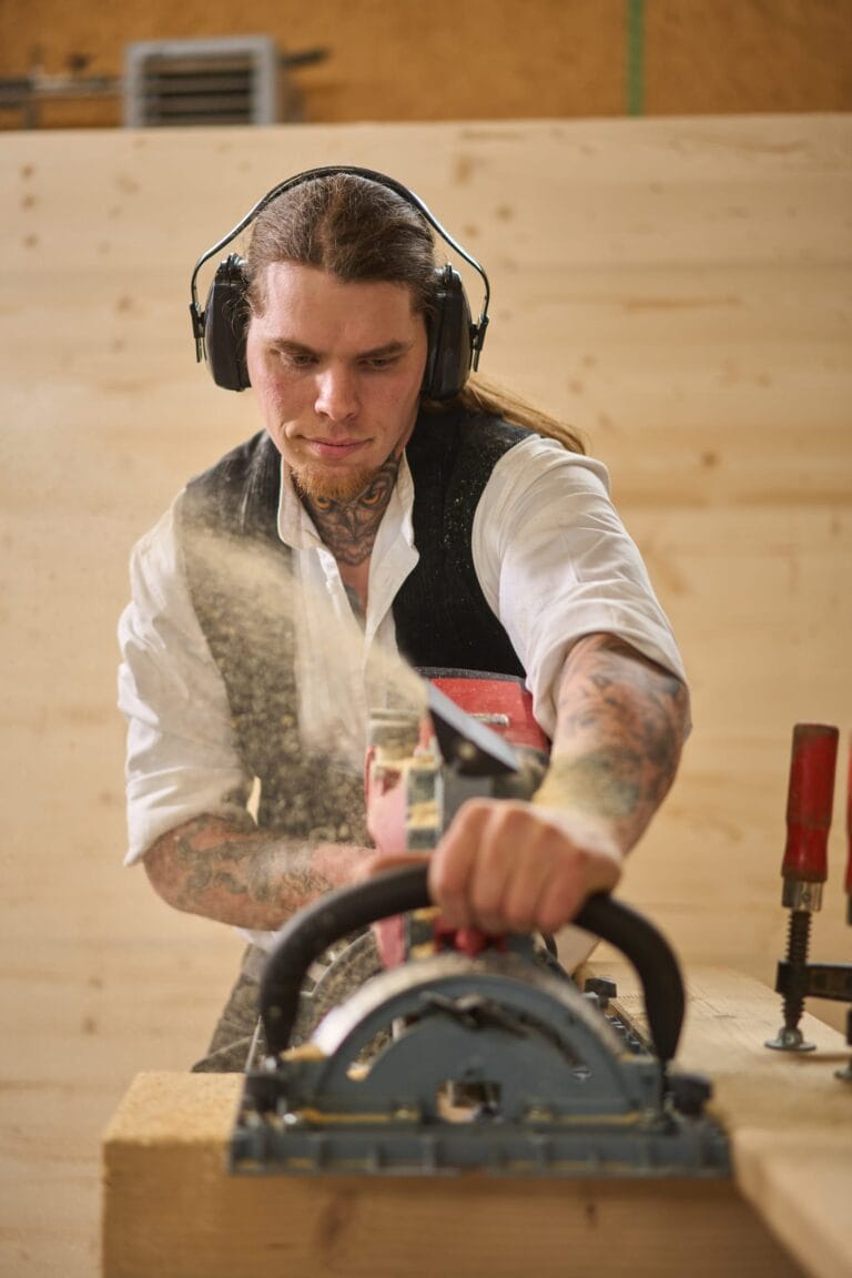 Nahaufnahme beim Sägen: Späne fliegen – Industriefotografie, Baustellenfotos und Handwerk, Frankfurt.