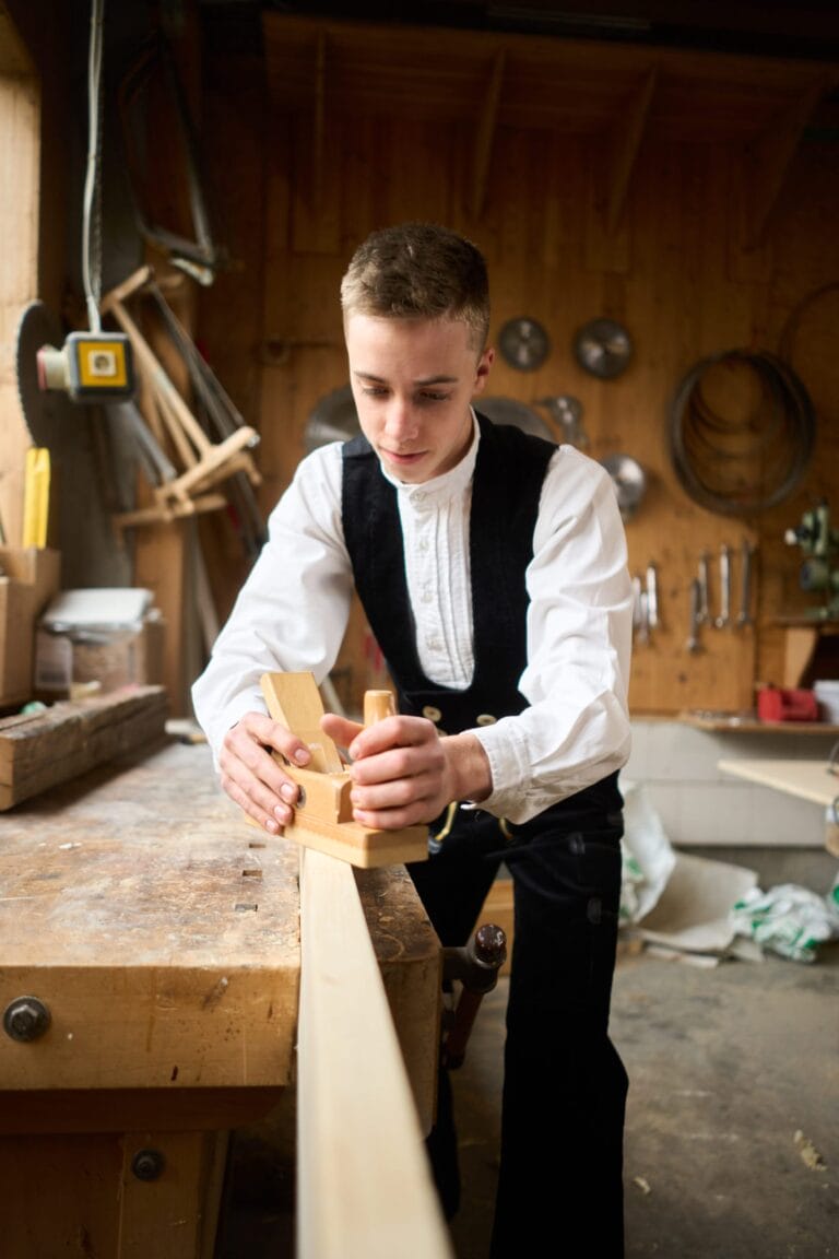 Azubi hobelt Holz in der Werkstatt – Mitarbeiterfotografie und Employer Branding Fotografie in Baden‑Württemberg.