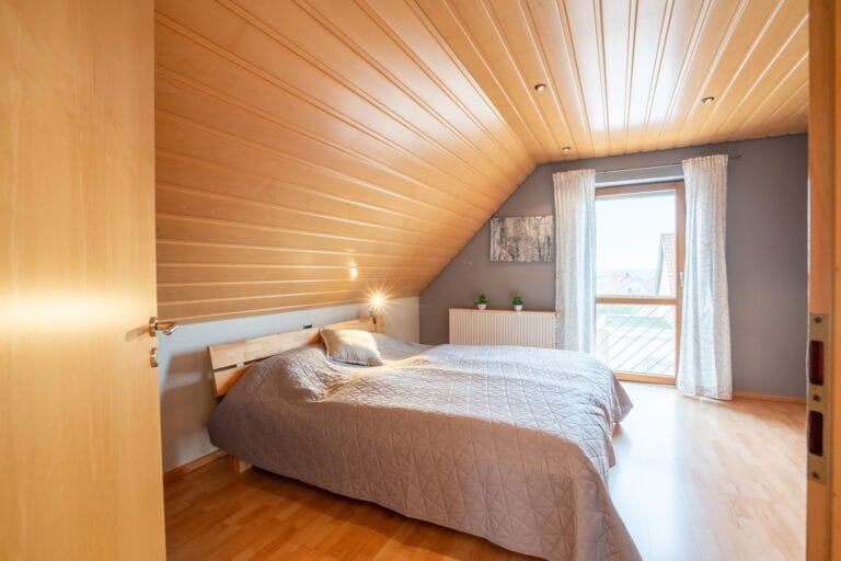 Schlafzimmer mit Doppelbett und großem Fenster – Immobilienfotografie in Speyer.