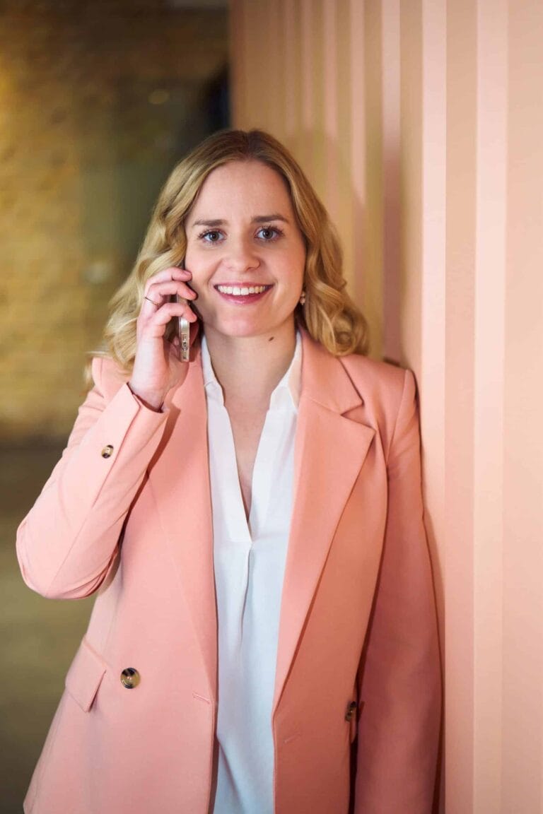 Personal Branding Fotografie Anwältin Langewender Karlsruhe Steamwork Frau in weißer Bluse steht angelehnt und telefonier